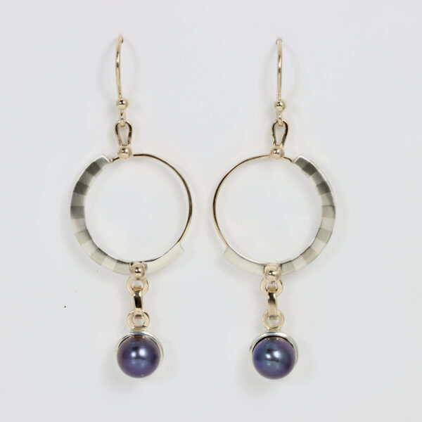 Earrings with a dangling black pearl