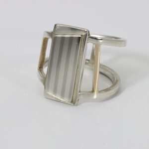 A wide open banded ring with a striped pattern and a contemporary style.