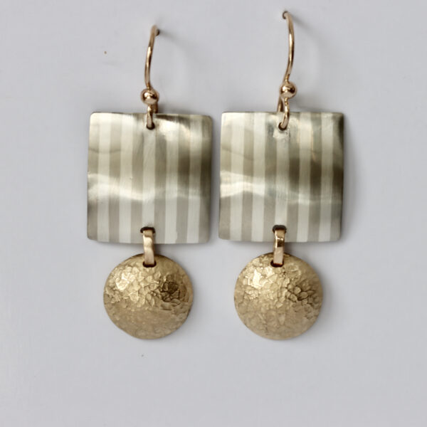 Earrings with a striped square and a dangled textured gold circle.