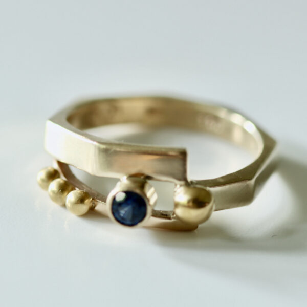 Gold Ring with Sapphire Gemstone is shown.