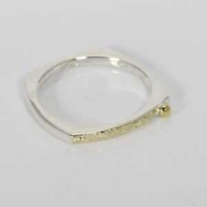 Square shaped ring with a gold texture on the top of the band.