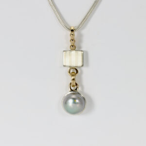 Striped pendant with a gray pearl. Sterling silver and 14k gold.