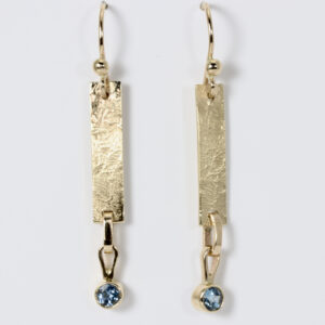 Textured 14k gold dangle earrings with a aquamarine.