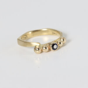 14k gold ring with a bezel set sapphire and gold balls.