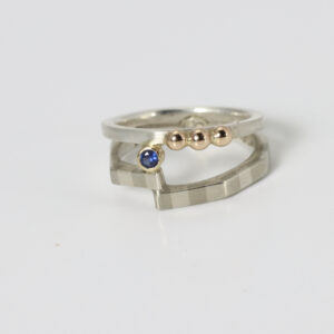 Contemporary ring fabricated with sterling silver and 14k gold with a sapphire.