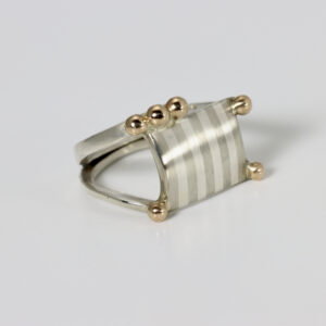 A Ring with a striped square and solid 14k gold balls.