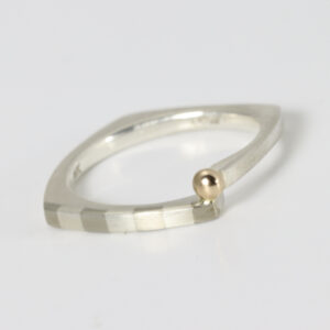 Sterling silver ring, squarish in shape with a striped pattern and an offset solid 14k gold ball.