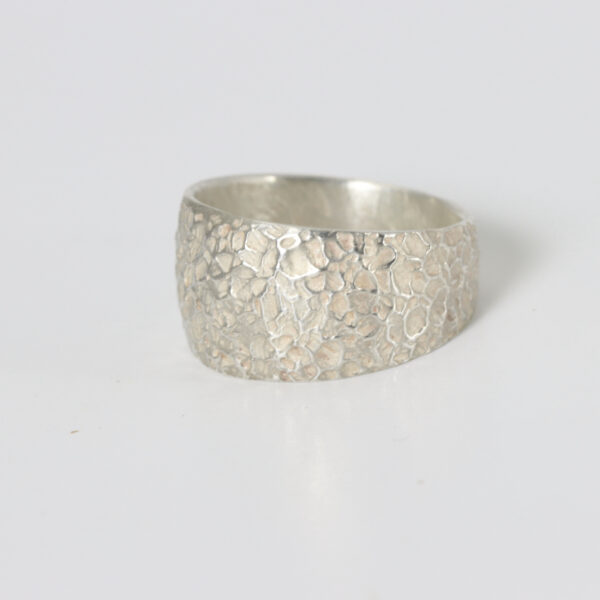 A sterling silver texture wide ring tapered towards the back.