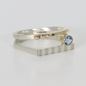 Double band ring with a striped pattern and an aquamarine. Hand-fabricated in sterling silver and 14k gold.