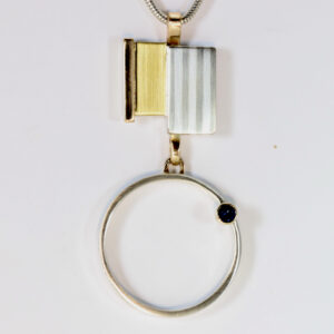Mixed metal pendant with a sapphire. Hand-fabricated in sterling silver, 14k, and 22k gold.