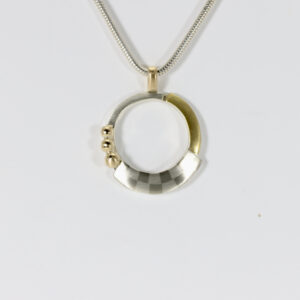 Mixed-metals checkerboard pendant. Hand-fabricated in sterling silver, 14k, & 22k. The Pendant is circular.