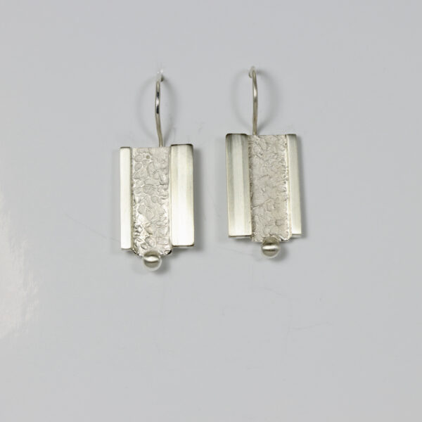 Textured, smooth, and striped drop earring in sterling silver.