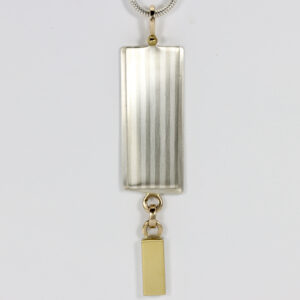 Italian Column Inspired Pendant. The smooth subtle striped pattern contrast with the lovely color of the dangling 22k section. The pendant is fabricated in sterling silver, 14k, and 22k gold.