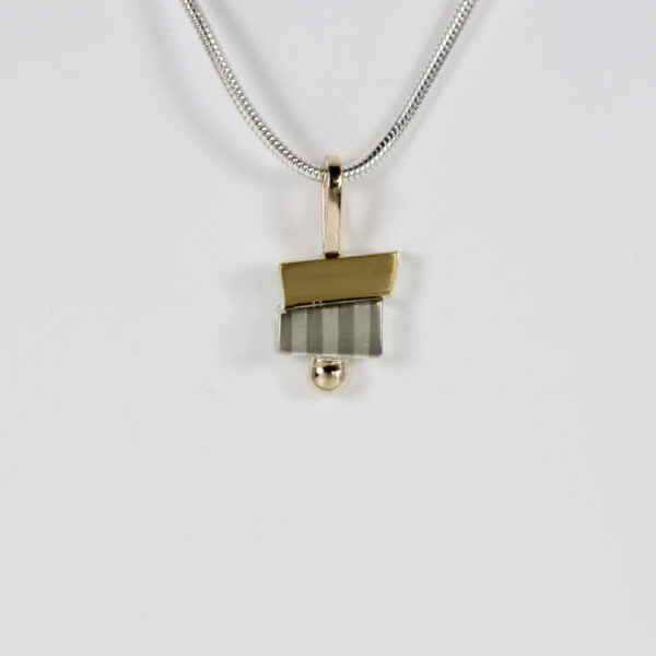 Small offset mixed-metal pendant. Hand-fabricated is sterling silver , 14k, and 22k gold with a subtle striped pattern.