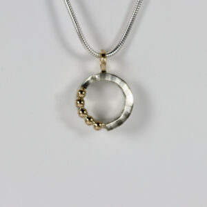 Small circular pendant with a striped pattern and five solid 14k gold balls.