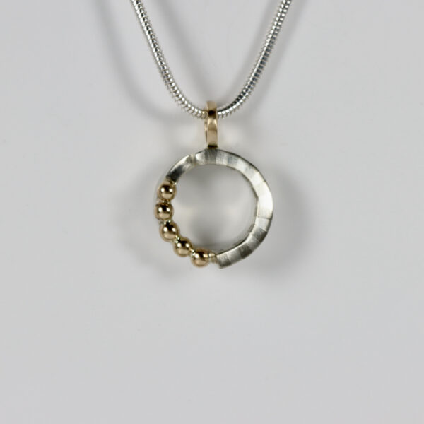 Small circular pendant with a striped pattern and five solid 14k gold balls.