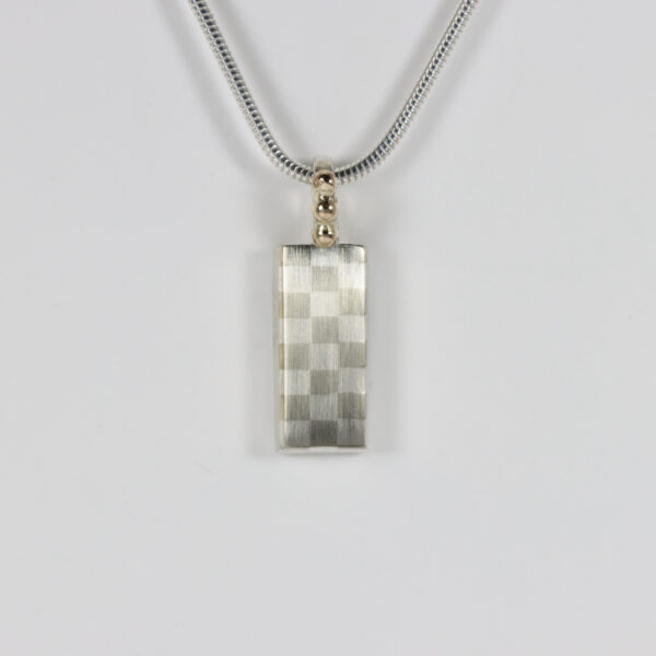 Subtle checkerboard pattern pendant with a 14k gold bail.