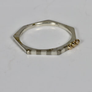 Narrow heptagon shaped ring with a subtle striped pattern and three 14k gold balls.