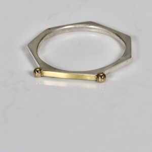 Narrow stacking ring fabricated in sterling silver, 22k, and 14k. The ring is heptagon shaped.