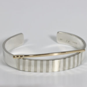Bold striped cuff bracelet hand-fabricated in sterling silver and 14k gold. Details include three solid 14k balls. The striped pattern is hand-fabricated.