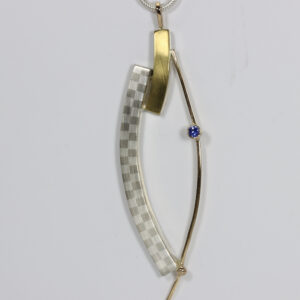 A curvy pendant hand-fabricated in sterling silver, 14k, and 22k gold. Details include a subtle checkerboard pattern and a sapphire.