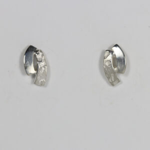 Curvy stud earring fabricated in sterling silver. Textured and smooth contrasting design.