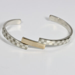 Tiered checkerboard cuff bracelet. Hand-fabricated in sterling silver and 14k gold. The gold is centered between two checkerboard patterns.