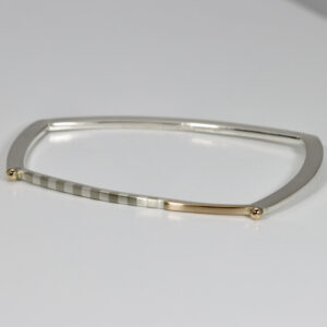 Trapezoid shape sterling silver bracelet with striped and gold details.