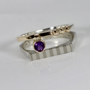 Contemporary amethyst ring. Hand-fabricated in sterling silver and 14k gold. The Ring is a double band. One band has a striped pattern and the second band has gold over silver and three solid 14k gold balls. The amethyst gemstone is AAA quality.