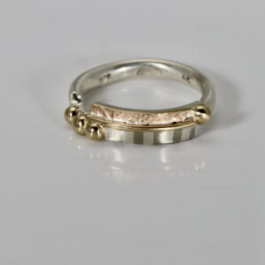 A sterling silver band featuring a subtle striped pattern and a 14k textured, accented with polished 14k yellow gold spheres resting along the surface.
