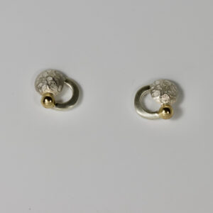 Circle post earrings. Fabricated in sterling silver with a solid 14k gold ball. The earring features a textured domed circle.