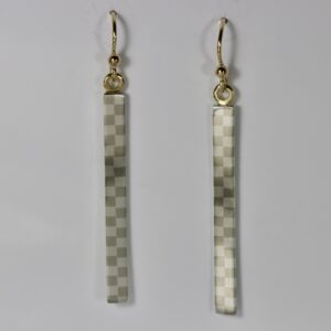 A pair of long, vertical bar-shaped dangling earrings. The slender rectangular metal surfaces feature a subtle, geometric checkerboard pattern that softly catches the light. The bars hang elegantly from 14k gold ear wires.