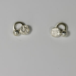 Sterling silver stud earrings. Three circular shapes create dimension and a textured circle add interest to the little post earring.